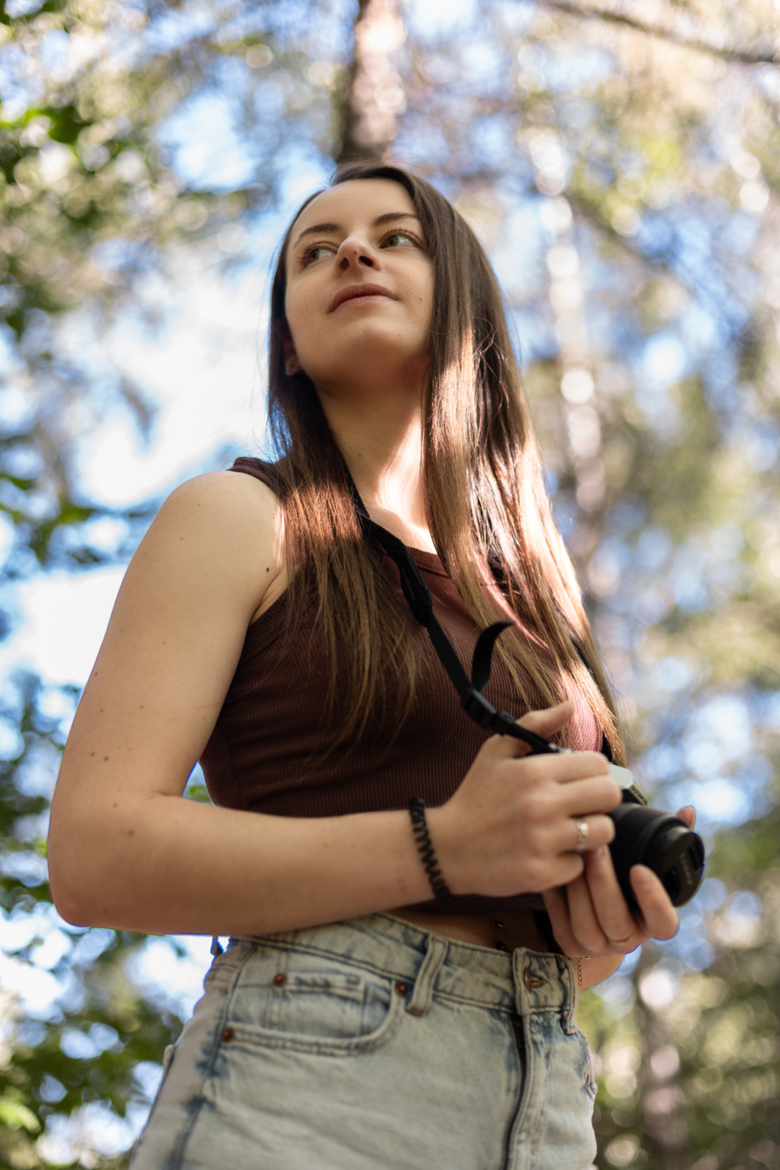 Femme avec un appareil photo dans la forêt
