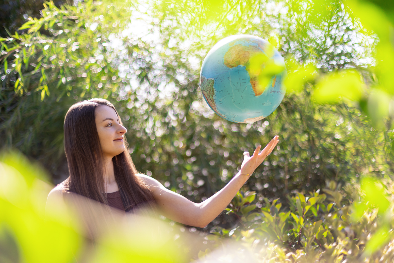 Femme tenant un globe terrestre dans la nature
